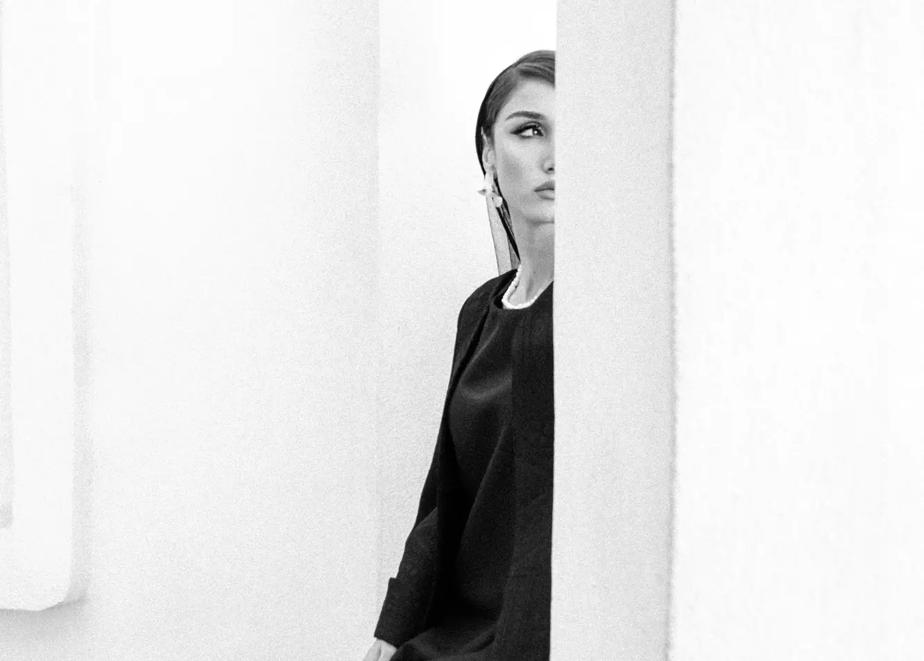 Mysterious Gaze: Woman in Black Elegance Peeking from Shadows