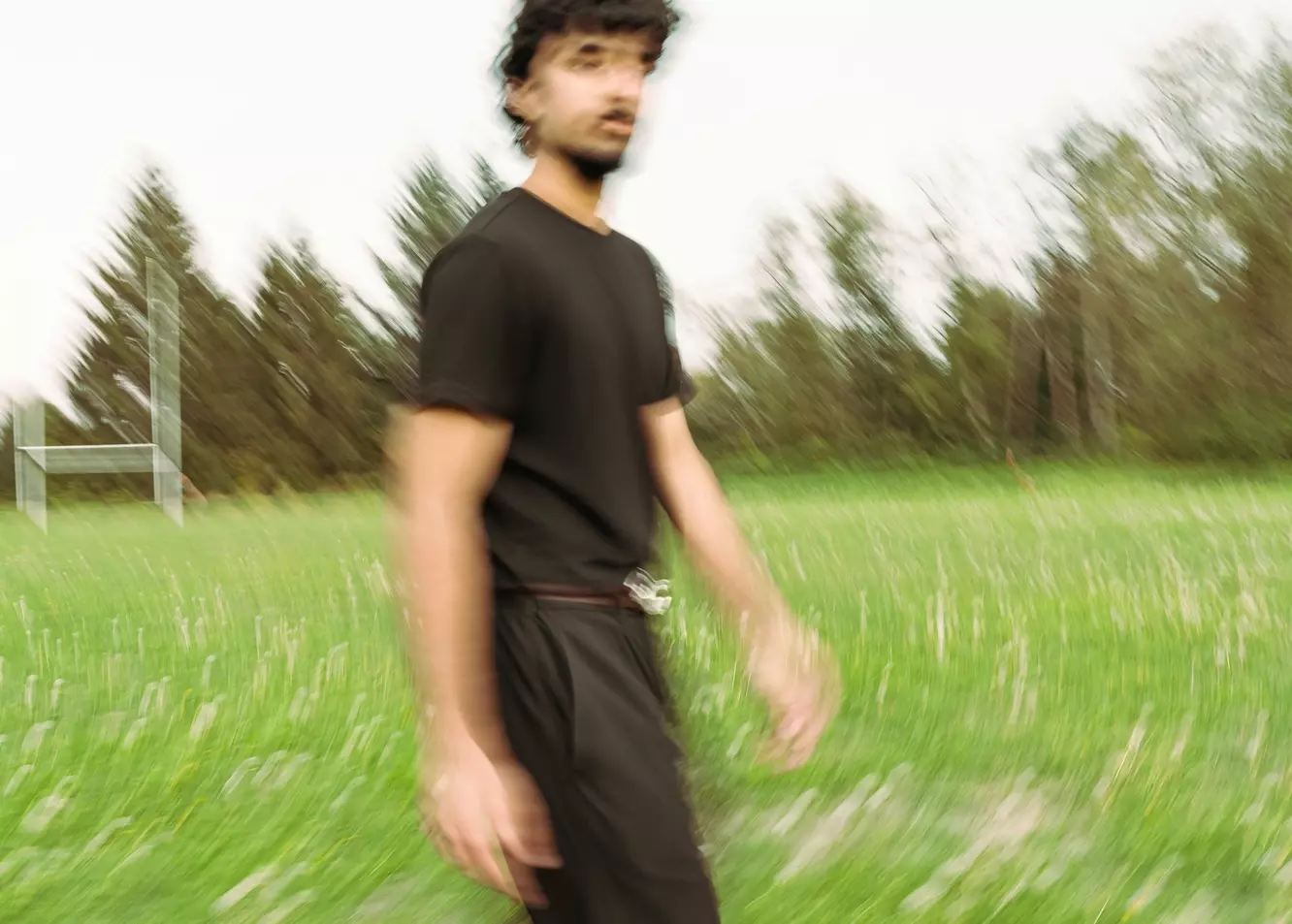 Dynamic Motion: Man Walking Through Blurry Green Field