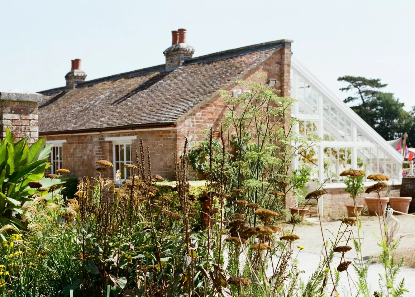 Charming Brick Cottage with Expansive Greenhouse and Lush Garden