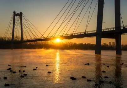 Golden Dawn: Majestic Bridge Over Misty River Sunset