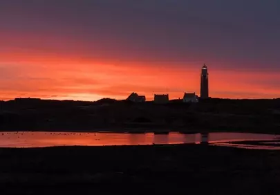 Dramatic Texel Sunset: Lighthouse Silhouette Against Fiery Sky