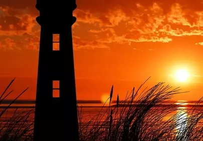 Dramatic Coastal Glow: Lighthouse Silhouette at Sunset