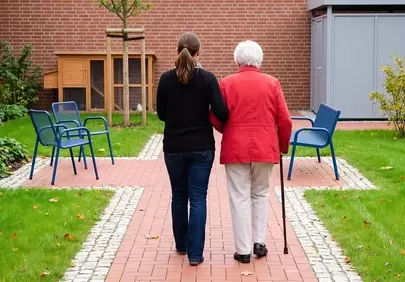 Heartwarming Autumn Stroll: Caregiver and Elderly Companion in Garden