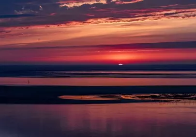 Dramatic Coastal Sunset: Fiery Hues Over Tranquil Waters