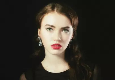 Striking Beauty: Young Woman with Vivid Red Lipstick and Elegant Earrings