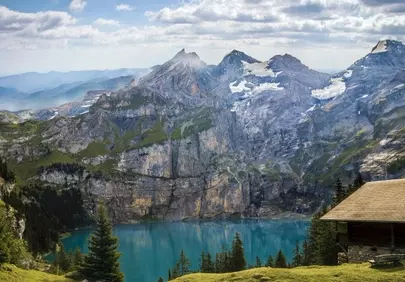 Breathtaking Alpine Panorama: Serene Lake & Mountain Cabin