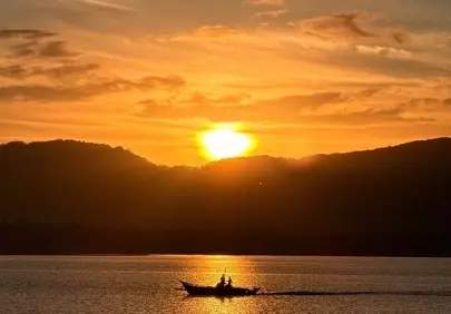 Breathtaking Sunset Silhouette: Rowboat on Golden Waters