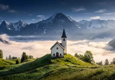 Breathtaking Alpine Dawn: Church Amidst Misty Mountains