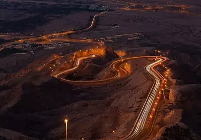 Breathtaking Night Drive: Winding Mountain Road Illuminated by Traffic