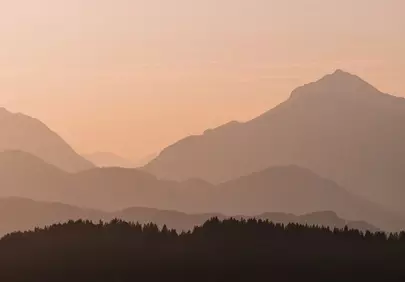 Serene Dawn: Layers of Mountains Bathed in Golden Light