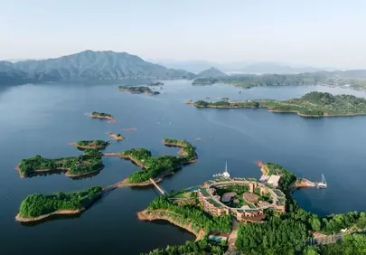 Breathtaking Aerial View: Serene Lake, Islands & Mountain Resort