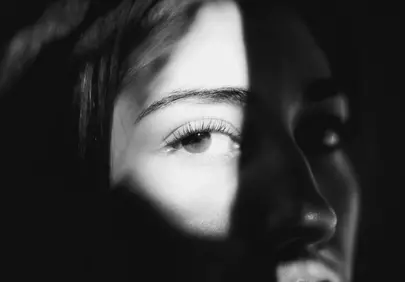 Striking Black and White Portrait: Enigmatic Gaze in Shadow