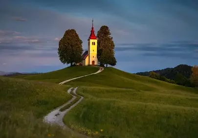 Enchanting Slovenian Church Bathed in Sunset's Golden Glow