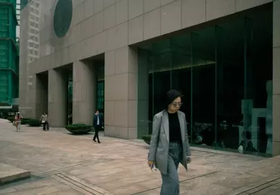 Urban Serenity: Woman Strolls Past Modern Architecture