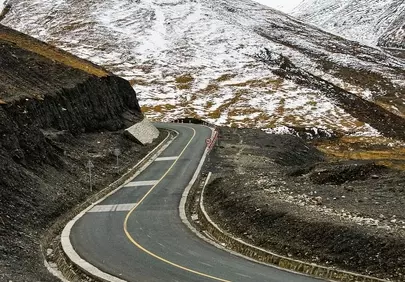 Dramatic Alpine Drive: Winding Road Through Karola Glacier's Snowy Peaks