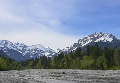 Majestic Alpine Peaks: Serene River Valley Vista
