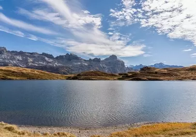 Breathtaking Alpine Panorama: Serene Lake Amidst Autumn Peaks