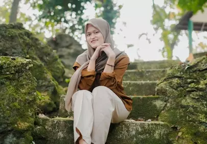 Serene Muslim Woman in Hijab Graces Mossy Stone Steps