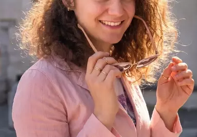 Radiant Joy: Sun-Kissed Woman with Curly Hair and Floral Charm