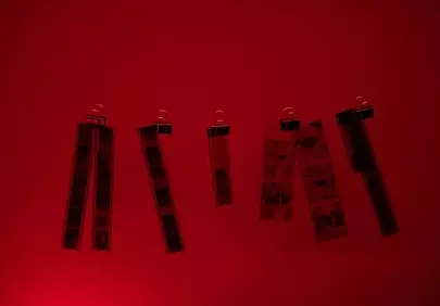 Dramatic Red Glow: Vintage Film Strips Drying in Darkroom