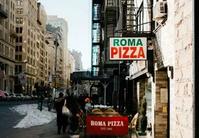 Vibrant Roma Pizza Sign on a Bustling City Street