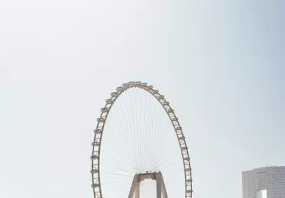 Dramatic Sky: Airplane Soars Over Iconic Ferris Wheel
