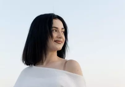 Serene Brunette Portrait: Natural Beauty Under Clear Skies