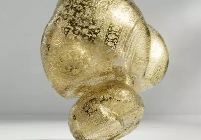 Glistening Gold: Abstract Sculpture on Reflective Surface