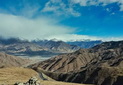 Breathtaking Mountain Panorama: Winding Road Through Majestic Peaks