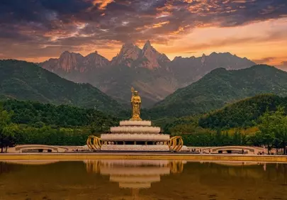 Serene Sunset: Golden Buddha Reflects Mountain Majesty