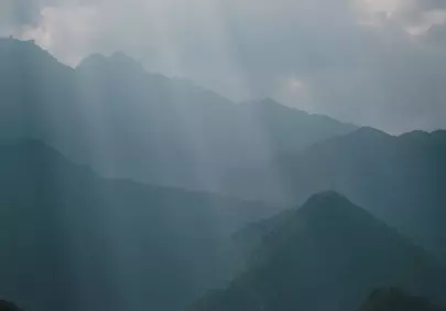 Mystical Sunbeams Pierce Hazy Mountain Ridges