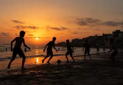 Golden Hour Joy: Kids' Sunset Beach Soccer Silhouettes