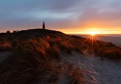 Dramatic Texel Sunset: Lighthouse Guardian Over Shimmering Dunes