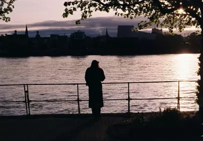 Enchanting Dusk: Solitary Figure Gazing at City Sunset