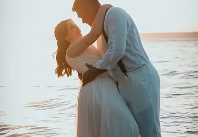 Romantic Sunset Kiss: Bride & Groom in Love at Sea