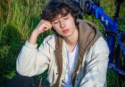 Serene Cyclist Rests Amidst Golden Hour Nature