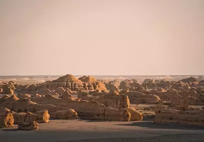 Dramatic Desert Sunset: Ancient Rock Formations Bathed in Warm Light