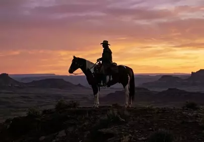 Majestic Sunset Ride: Cowboy Silhouetted in Canyon Twilight