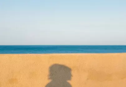 Striking Silhouette: Person's Shadow on a Coastal Wall
