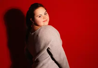 Empowered Beauty: Young Woman with Down Syndrome against Red