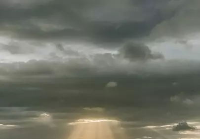 Dramatic Sun Rays Piercing Through Cloudy Sunset Sky