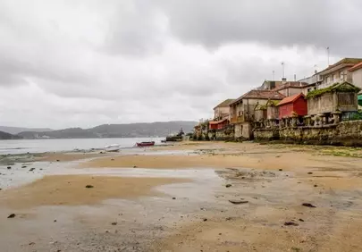 Charming Coastal Village: Timeless Beachfront Architecture Under Cloudy Skies