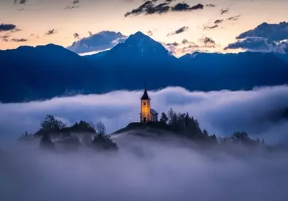 Mystical Slovenian Chapel Emerging from a Foggy Dawn