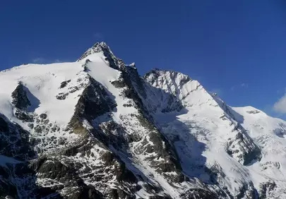Majestic Alpine Peaks: Snow-Covered Grandeur Under a Blue Sky