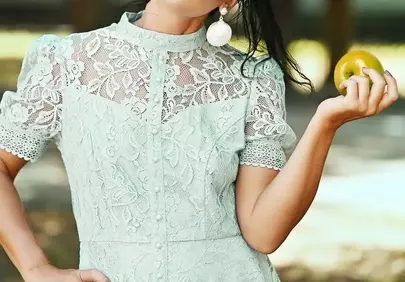 Charming Woman in Lace Dress Holding Apple in Nature's Embrace