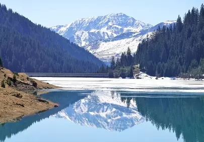 Stunning Alpine Panorama: Snow-Capped Peaks Reflected in Tranquil Lake