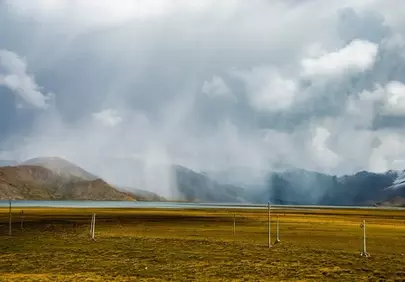 Dramatic Tibetan Plateau Storm: Rain Curtain Over Alpine Lake