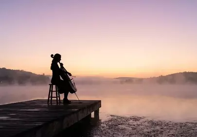 Enchanting Morning Symphony: Cellist on a Misty Lake Dock at Sunrise