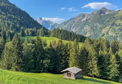 Serene Alpine Morning: Tranquil Hut Amidst Majestic Peaks