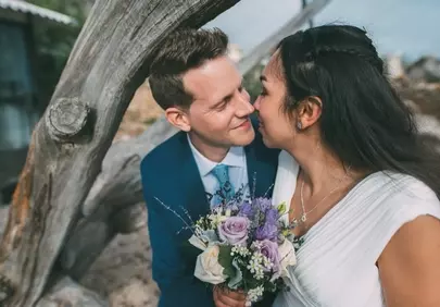 Enchanting Beach Wedding: A Tender Kiss Amidst Nature's Beauty